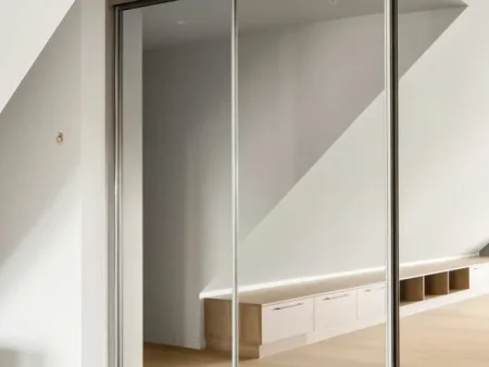 Puerta corredera empotrada oculta en tabique para paso entre cocina y salón en Gràcia